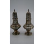 A pair of vintage repousse silver scrolling foliate design sugar sifters with flame finials.