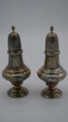A pair of vintage repousse silver scrolling foliate design sugar sifters with flame finials.