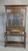 A Jacobean style oak hall stand, 20th Century, with mirrored back, glove box to centre and