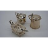 Three silver mustard pots with blue glass liners, two with spoons (one silver plate). One with a