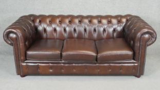 A three seater Chesterfield sofa, handmade by Chesterfields of England in deep buttoned and studded