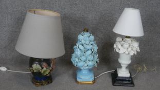 A collection of three ceramic floral design table lamps. One hand painted with relief hollyhocks