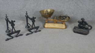 A collection of metalware. Including a pair of cast iron firedogs, a set of brass weighing scales by