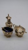 A three part silver geometric design Art Deco cruet set with blue glass liners. Hallmarked BBSld for