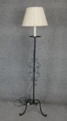 A mid century wrought iron lamp standard on tripod scrolling supports. H.165cm