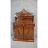 A Victorian flame mahogany chiffonier with carved superstructure above arched panel doors on