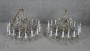 A pair of large gilt metal framed eighteen branch chandeliers with scrolling arms and cut crystal