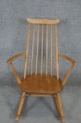 A vintage Ercol child's Windsor rocking chair with beech frame and burr elm seat.