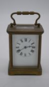 A 1900's brass carriage clock with bevelled glass plates and white enamel dial. H.11 W.8 D.7cm