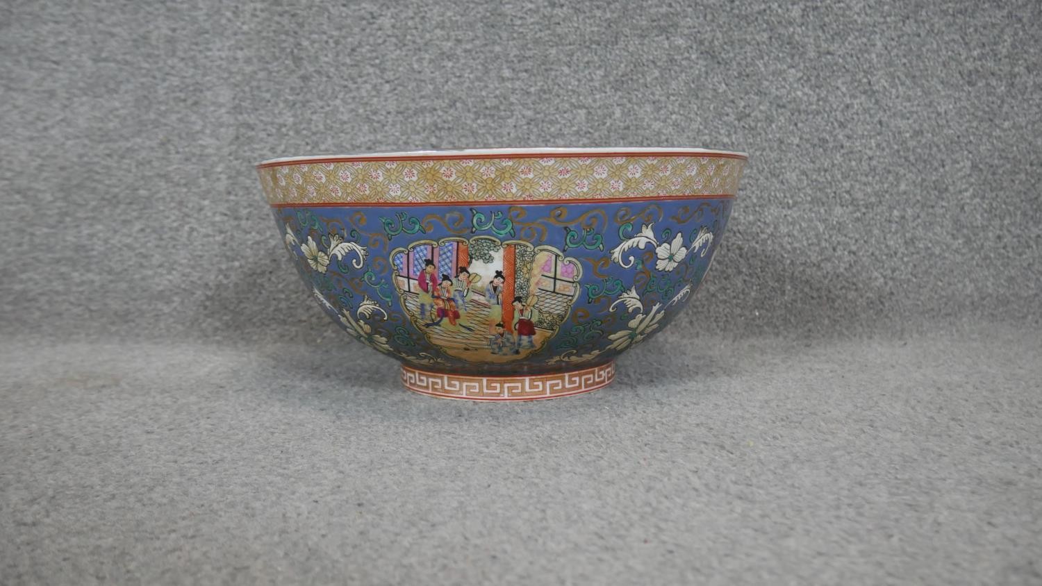 A 20th century Chinese porcelain hand painted bowl decorated with temple scenes, abstract patterns