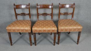 A set of three late Georgian mahogany bar back dining chairs on ring turned tapering supports.