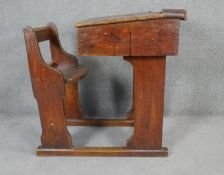 A vintage oak school desk with integral bench seat and sliding adjustable writing slope section. H.