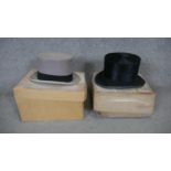 Two boxed Victorian moleskin top hats. One pale grey with a black band and the other black. One from