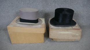 Two boxed Victorian moleskin top hats. One pale grey with a black band and the other black. One from