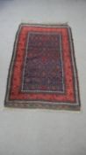 An Afshar rug with repeating diamond hooked medallions on a midnight ground within floral multiple