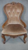 A Victorian style carved frame nursing chair on cabriole supports.