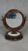 A 19th century mahogany Empire style swing toilet mirror on circular marble base. H.60 W.50cm