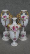 Three hand painted rose design porcelain twin handled urns. The handles gilded on pedestal bases.