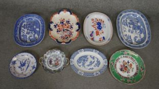 A collection of eight hand painted ceramic platters and plates. Including a Spode blue and white