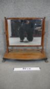 A Regency mahogany swing toilet mirror on platform base resting on brass lion's paw feet. H.56 W.