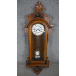 A 19th century Vienna regulator wall clock with eight day movement and white enamel dial in a carved