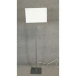 A contemporary metal standard lamp with linen block shade. H.142cm