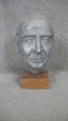 A sculpted metal head of an elderly gentleman mounted on a wooden stand. H.37cm