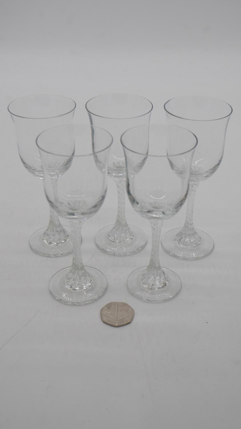 A set of five Victorian twist stem clear sherry glasses with flared rims.