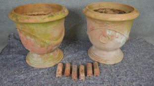 Two large terracotta pedestal planters with swag design along with six terracotta edging tiles. H.56