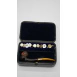 A leather box with velvet lining containing a selection of rolled gold and mother of pearl shirt