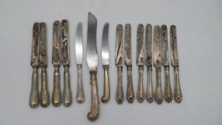 A collection of fourteen silver and silver plated handled knives. Including a carving knife. Various