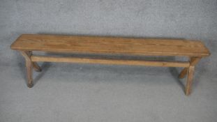 A vintage pitch pine bench on X framed stretchered supports. H.45 W.170 D.25cm