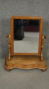A Victorian satin walnut dressing mirror on shaped base. H.60 W.48 D.22cm
