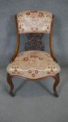 A Victorian carved walnut nursing chair on cabriole supports.