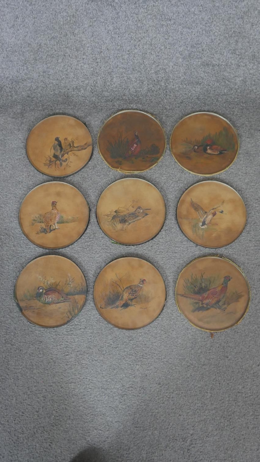 A set of nine 19th century watercolours under glass circular place mats with various game birds.