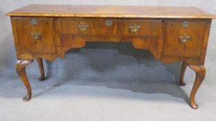 A mid Georgian style figured walnut sideboard raised on carved cabriole supports. H.92 W.183 D.58cm