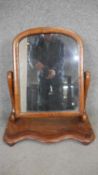 A Victorian mahogany toilet mirror on shaped base. H.69 W.54cm