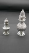 Two Victorian silver repousse pepper shakers with gilded interior. Various British hallmarks. Weight