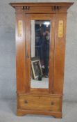 A late 19th century light oak Arts and Crafts wardrobe with Glasgow school inspired inlaid panels.