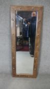 An Eastern teak metal studded mirror. H.122cm