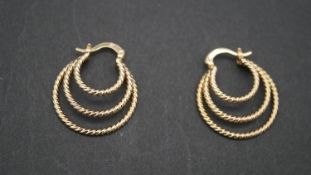 Yellow metal (tests higher than 9 carat) rose design triple hoop earrings. 6G