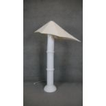 A French white ceramic bamboo design standard lamp with abstract triangular canvas shade. Makers