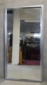 A large bevelled wall mirror in moulded silver frame. H190 W100