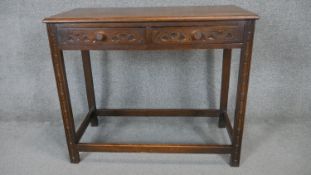 A mid century oak Jacobean style side table with carved frieze drawers on square stretchered