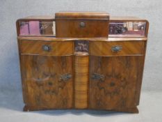 A mid century Art Deco style burr walnut drinks cabinet with central sliding fitted cocktail section