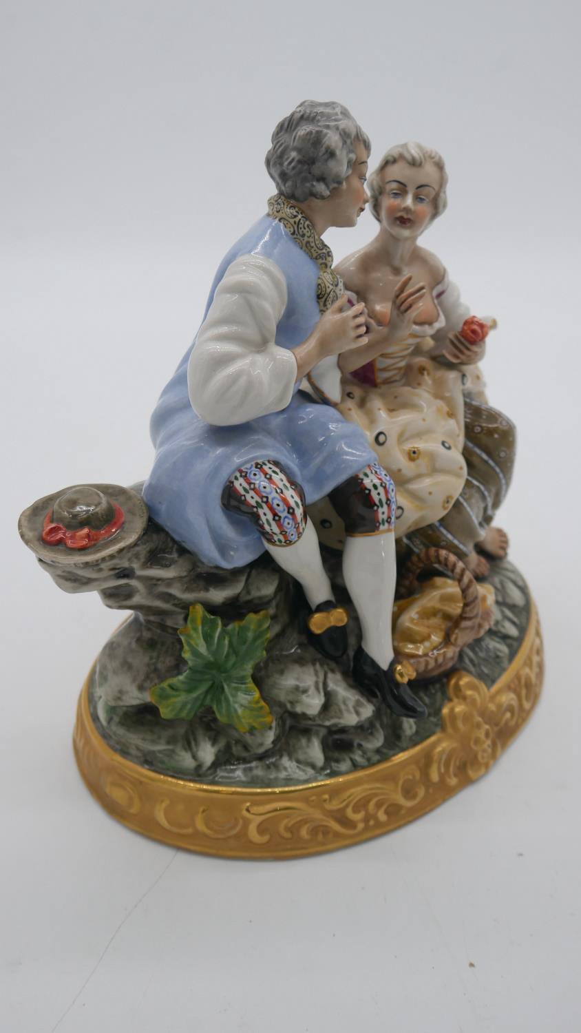 A hand painted porcelain figure group of a pair of lovers seated on a rocky outcrop with picnic - Image 4 of 7