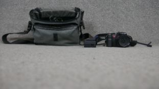 A Leica V-LUX 2 camera with acessories, cables and manual and over shoulder carrying case.
