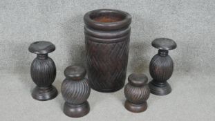Four carved stained candle holders with bulbous form and a geometric design carved hardwood vase.