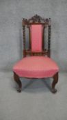 A mid 19th century rosewood nursing chair with carved top rail and barleytwist supports on carved