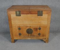 A solid light elm Korean cabinet with lift off panels to upper section above panel doors to cupboard